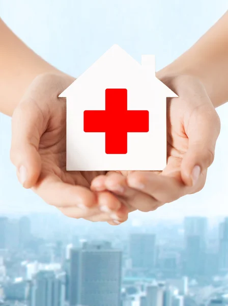 Hands holding paper house with red cross — Stock Photo, Image