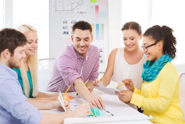 Diseñadores de interiores sonrientes trabajando en la oficina — Foto de Stock