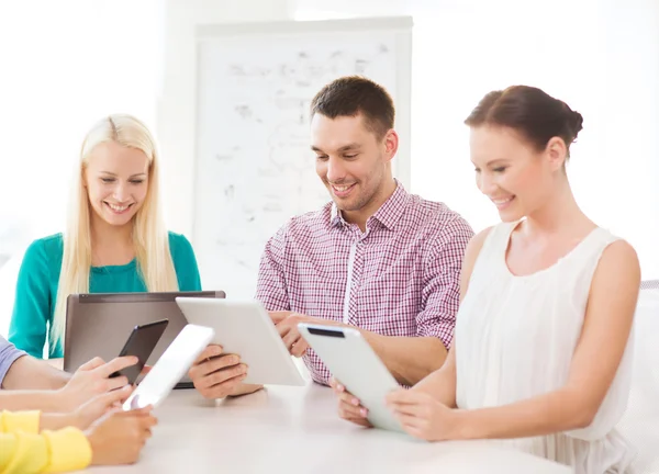 Lächelndes Team mit Tischcomputer und Laptop im Büro — Stockfoto