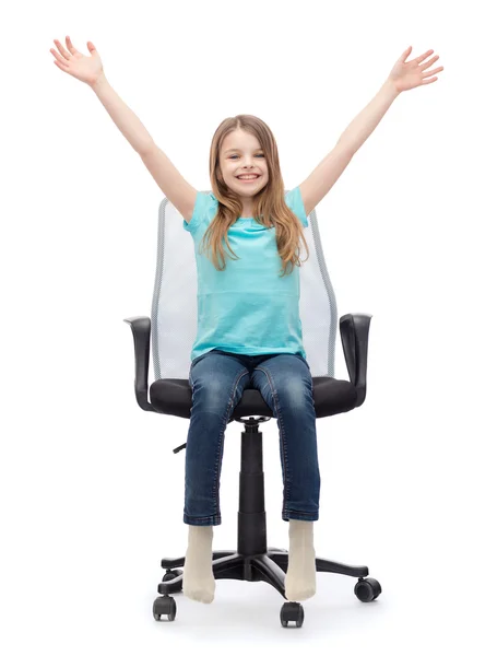 Smiling little girl sitting in big office chair — Stock Photo, Image