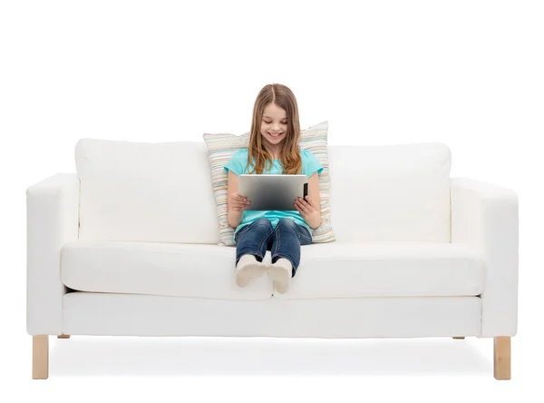 Μικρό κορίτσι που κάθεται στον καναπέ με τα tablet pc comuter — Φωτογραφία Αρχείου
