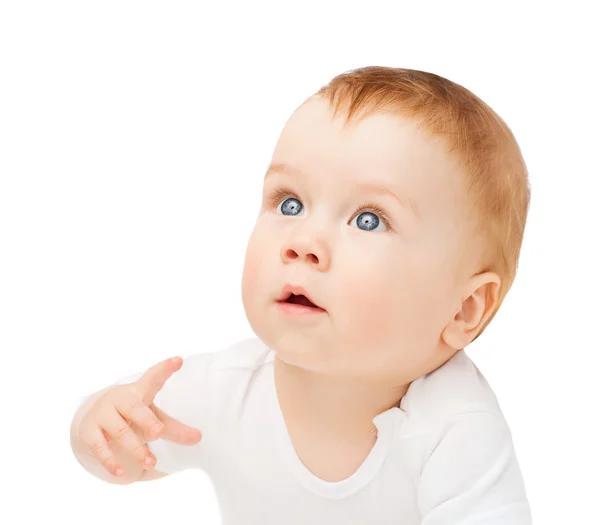 Curious baby lying on floor and looking up Royalty Free Stock Images