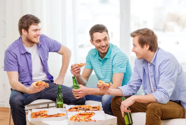 Улыбающиеся друзья с пивом и пиццей тусуются — стоковое фото