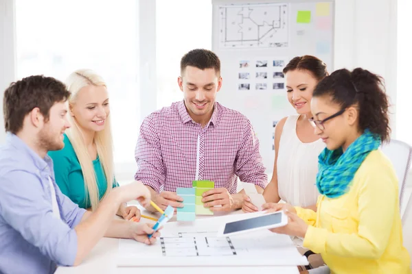 Diseñadores de interiores sonrientes trabajando en la oficina — Foto de Stock