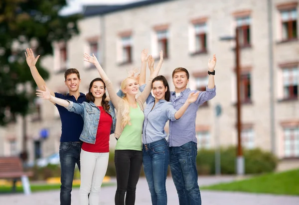 Grupo de estudiantes sonrientes saludando con las manos —  Fotos de Stock