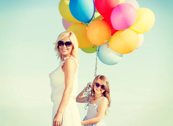 Mutter und Kind mit bunten Luftballons — Stockfoto