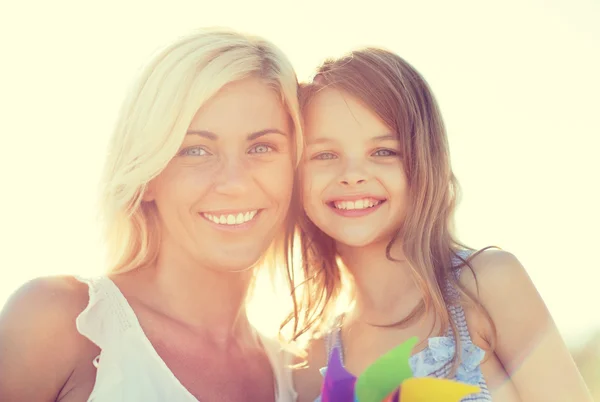 Happy mother and child girl with pinwheel toy — Stock Photo, Image