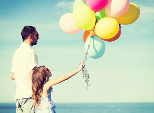 Far och dotter med färgglada ballonger — Stockfoto