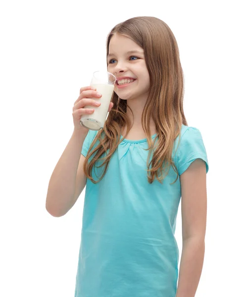 Усміхнена маленька дівчинка п'є молоко зі скла — стокове фото
