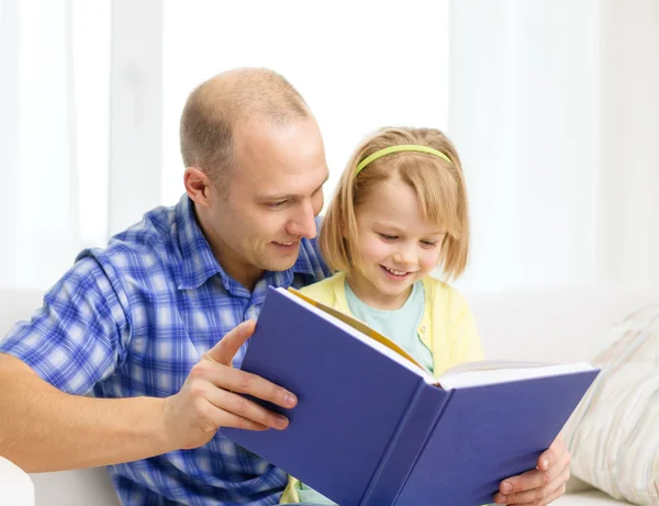 Usměvavý otec a dcera s knihou doma — Stock fotografie