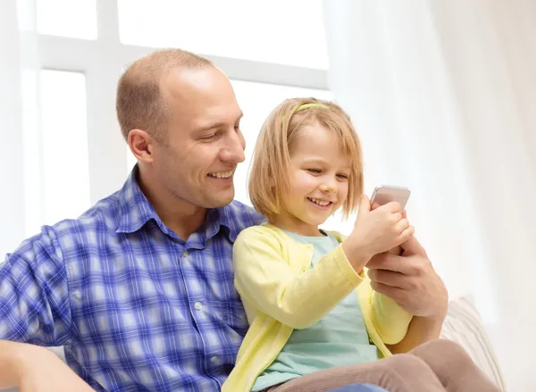 Happy father and daughter with smartphone — Stockfoto