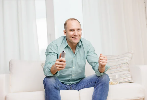 Smiling man watching sports at home — Stock Photo, Image