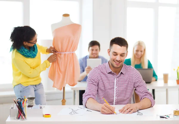 Diseñadores de moda sonrientes trabajando en la oficina — Foto de Stock