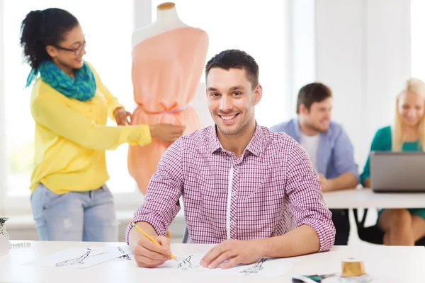 Diseñadores de moda sonrientes trabajando en la oficina — Foto de Stock