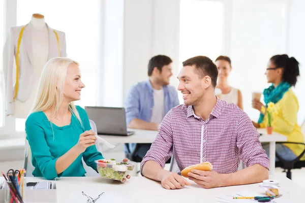 Diseñadores de moda sonrientes almorzando en la oficina — Foto de Stock