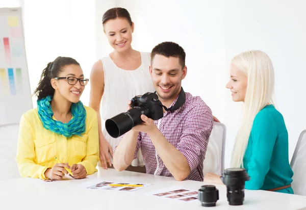 Χαμογελώντας ομάδα με photocamera που εργάζονται στο γραφείο — Φωτογραφία Αρχείου