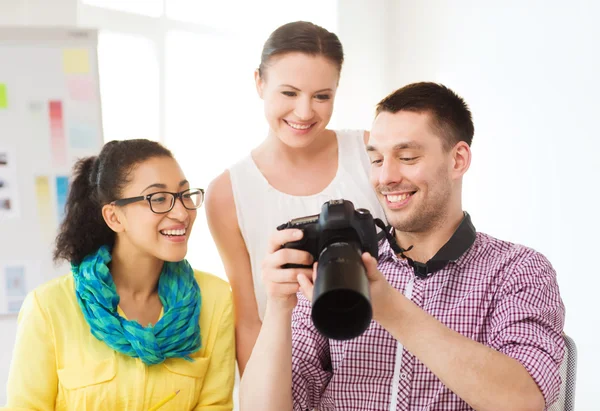 Sorrindo equipe com fotocâmera trabalhando no escritório — Fotografia de Stock