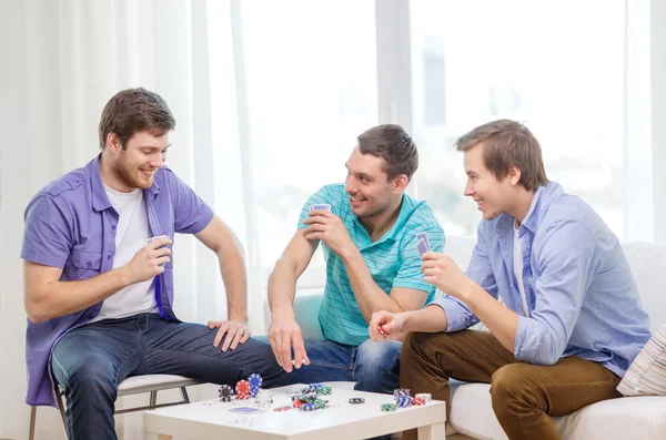 Glad tre manliga vänner spela poker hemma — Stockfoto