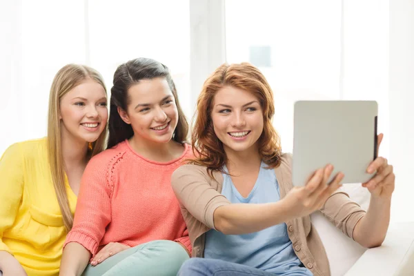 Tres chicas adolescentes sonrientes con tableta PC en casa —  Fotos de Stock