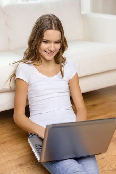 Sorrindo adolescente com computador portátil em casa Fotos De Bancos De Imagens