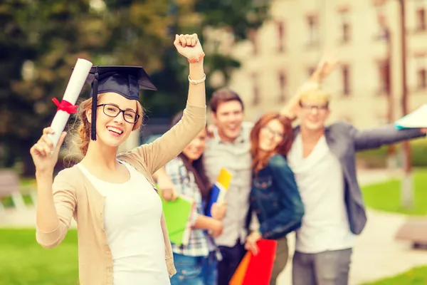 Smiling teenage girl in corner-cap with diploma — Stock Photo, Image