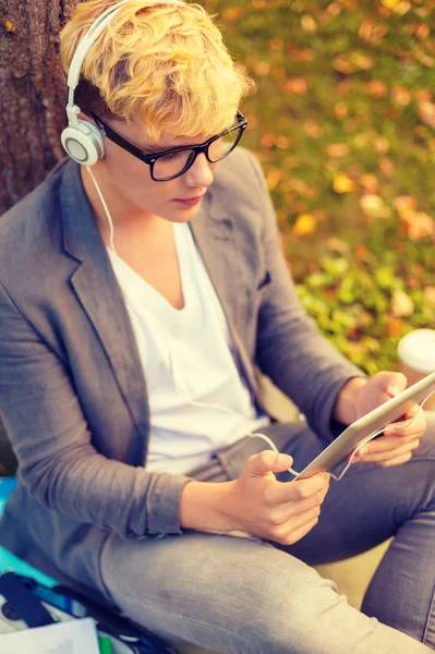 Smiling male student in eyeglasses with tablet pc — Stock Photo, Image