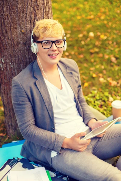 Smiling male student in eyeglasses with tablet pc — Stock Photo, Image