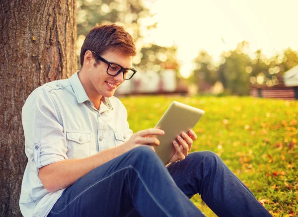 Estudiante masculino sonriente en anteojos con tableta pc —  Fotos de Stock