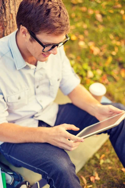 Smiling male student in eyeglasses with tablet pc — Stock Photo, Image