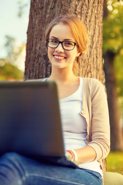 Adolescent souriant dans des lunettes avec ordinateur portable — Photo