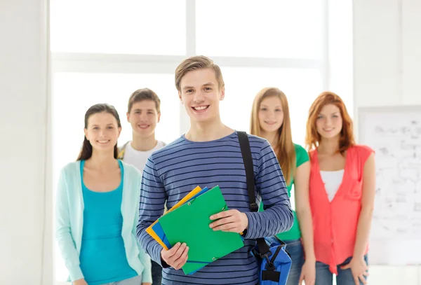 Lächelnde Studenten mit pubertierendem Jungen vor — Stockfoto