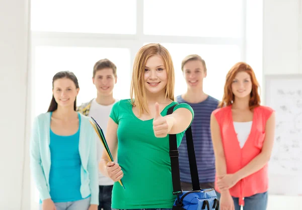 Lachende studenten met tienermeisje vooraan — Stockfoto