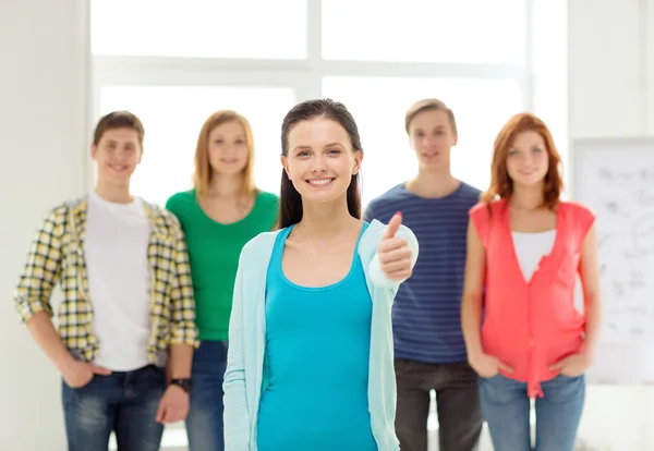 Étudiants souriants avec adolescente devant — Photo