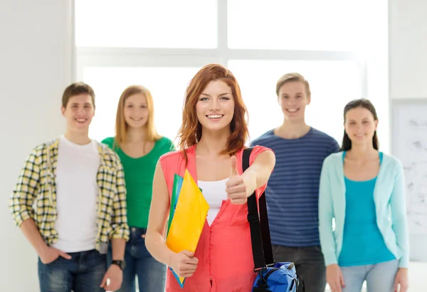 Smiling students with teenage girl in front — Stock Photo, Image