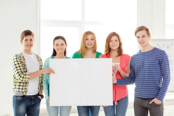 Studenten op school houden wit leeg bord — Stockfoto