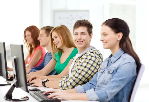 Estudiante sonriente con computadora estudiando en la escuela —  Fotos de Stock