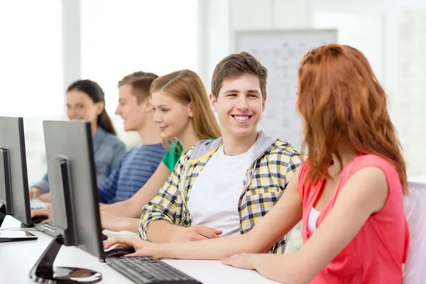 Estudiantes sonrientes en clase de informática en la escuela —  Fotos de Stock