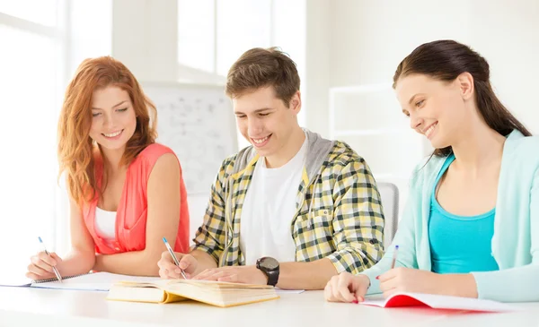 Estudiantes con libros de texto y libros en la escuela — Foto de Stock