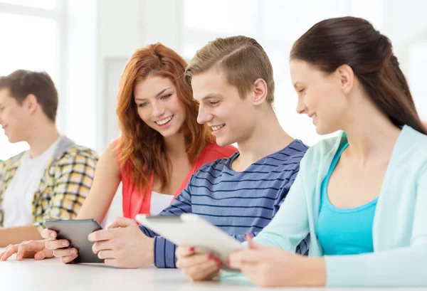Usmívající se studenti s tablet pc ve škole — Stock fotografie