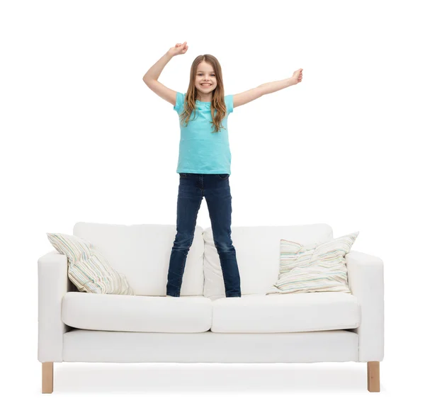 Leende liten flicka hoppande eller dansa på soffa — Stockfoto