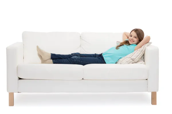 Uśmiechnięta dziewczynka leżąca na kanapie — Zdjęcie stockowe