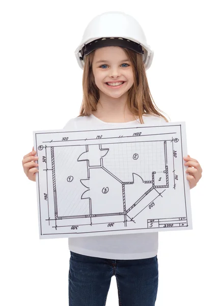 Smiling little girl in helmet showing blueprint — Stock Photo, Image