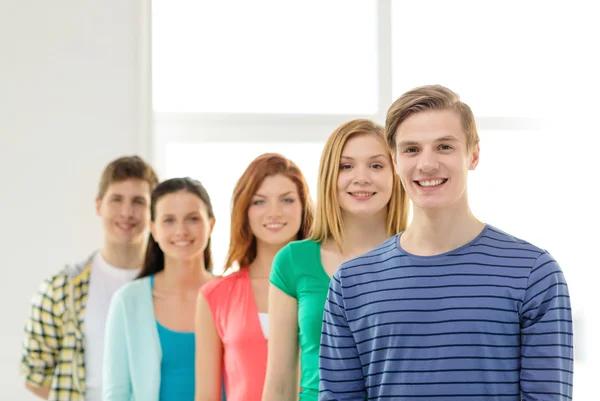 Estudiantes sonrientes con adolescente en frente — Foto de Stock