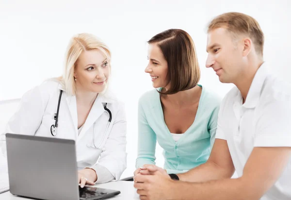 Médico con pacientes mirando el portátil —  Fotos de Stock