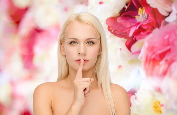 Ruhige junge Frau mit dem Finger auf den Lippen — Stockfoto