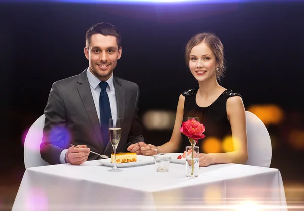 Smiling couple eating dessert at restaurant — Stock Photo, Image
