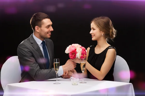 Sonriente hombre dando ramo de flores a la mujer — Foto de Stock