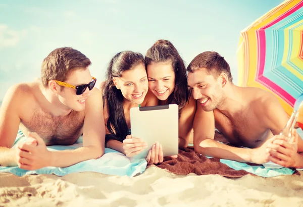 Grupo de pessoas sorridentes com tablet pc na praia — Fotografia de Stock