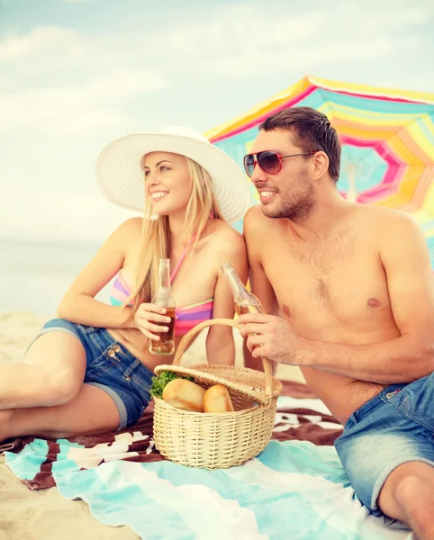 Pareja sonriente haciendo picnic en la playa —  Fotos de Stock