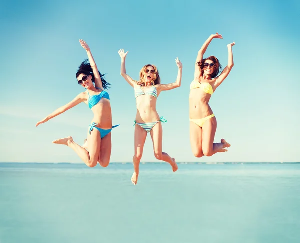 Girls jumping on the beach — Stock Photo, Image